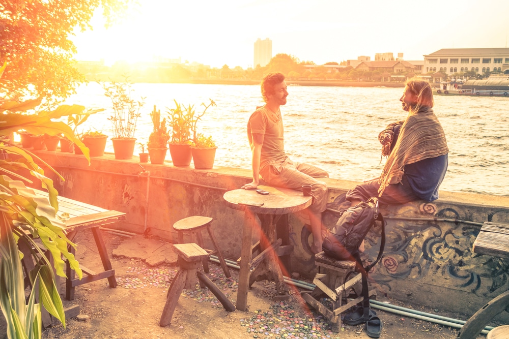 Couple of best friends travelers talking at sunset