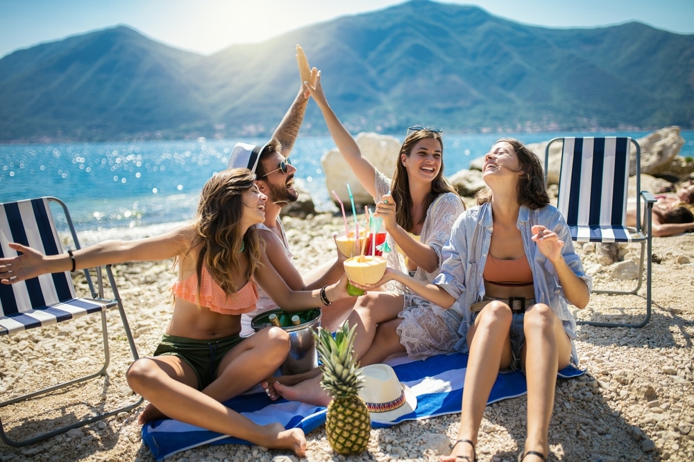 Happy Friends Having Fun With Tropical Cocktails On Beach Party.