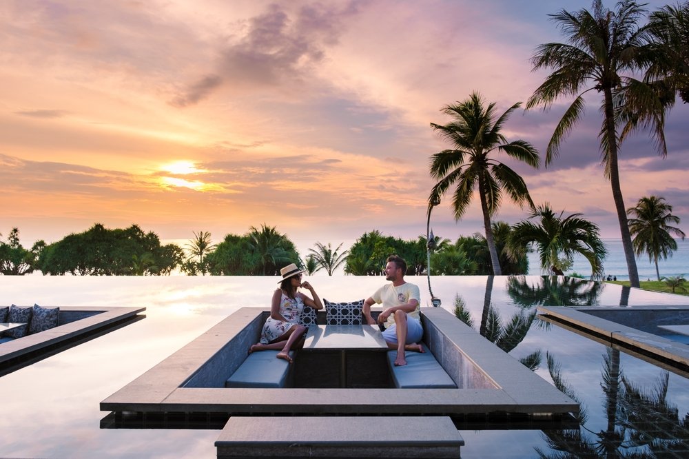 Couple Watching The Sunset In An Infinity Pool