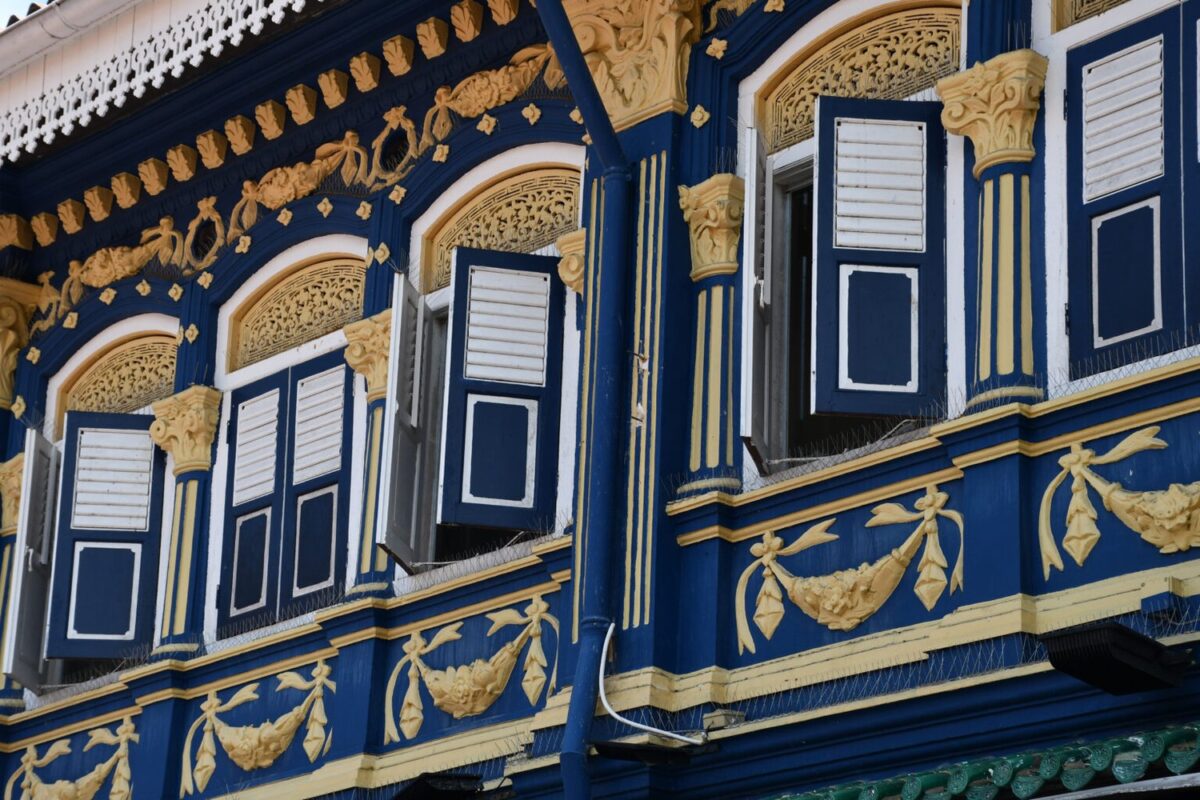 Colorful facade with window shutters at the Singapore Visitor Centre at CUBE – Boutique Capsule Hotel on Bussorah Street in Kampong Glam.