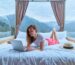 Freelancer Woman Traveler Lying On Bed With Mountain View And