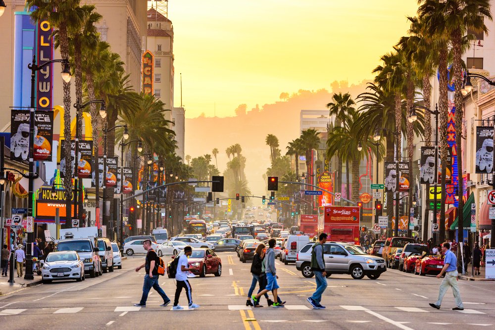 LOS ANGELES, CALIFORNIA - Traffic and pedestrians on Hollywood Boulevard at dusk. The theater district is famous tourist attraction.