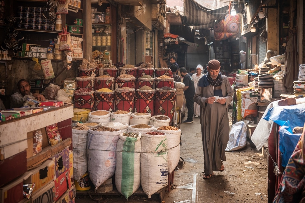 An Egyptian man walking in the narrow streets of the spice market a busy souk popular with locals and tourists near Khan El Khalili Bazaar, Al Hussein, Cairo, Egypt