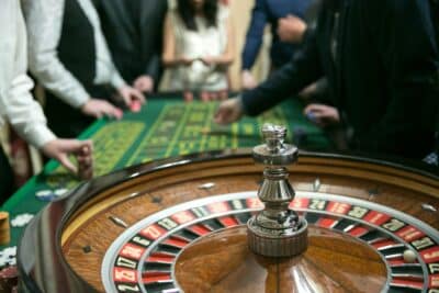 Casino roulette with people making bets in background