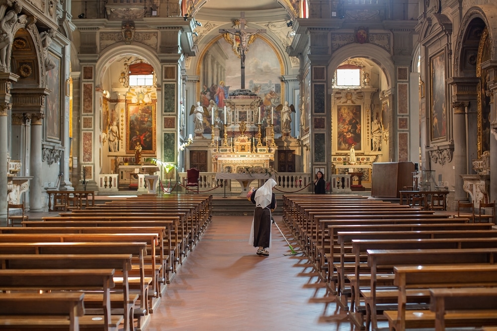 Florence, Italy, An elderly nun sweeping the floors inside the Chiesa di Ognissanti, also known as The All Saints Church