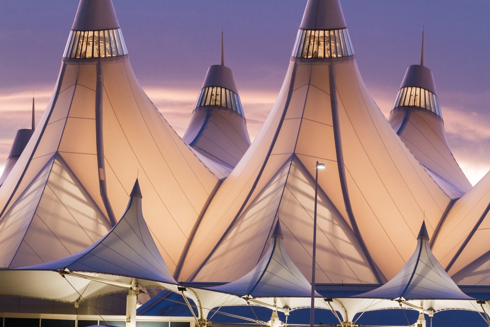 Glowing tents of DIA at sunrise. Denver International Airport well known for peaked roof. Design of roof is reflecting snow-capped mountains.