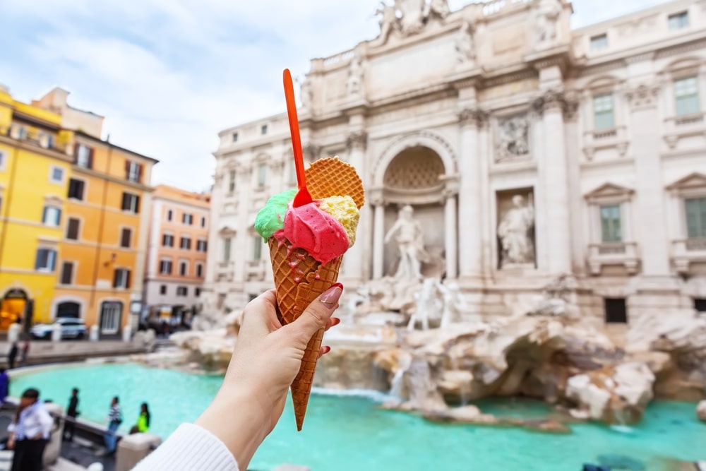 Italian ice cream gelato in front of amazing Trevi Fountain in Rome, Italy. Trevi Fountain or Fontana di Trevi.