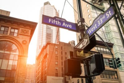 Street sign of Fifth Ave and West 33rd St at sunset in New York City