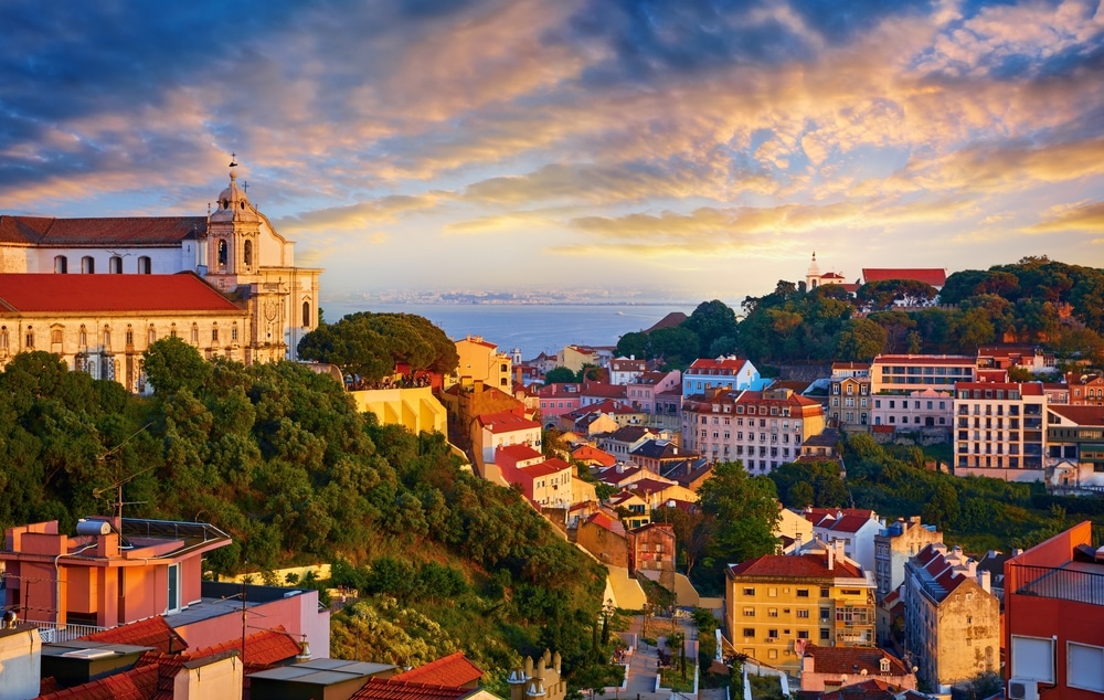 Lisbon panorama of sunset. Portugal. Evening picturesque with beautiful sky and sunny light at houses historic old town in district Alfama Lisboa