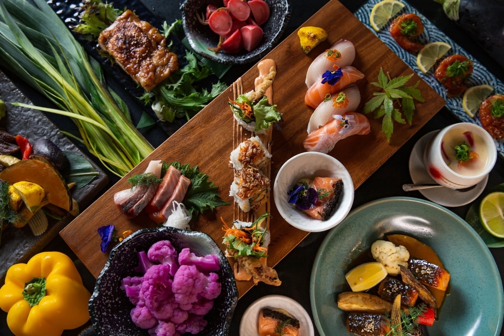 Top view Japanese sushi kaiseki fine dining platter combo set on the wooden board with vegetable display